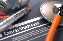 Cancer treatment. Medical Concept on Grey Background with Blurred Text and Composition of Pills, Syringe and Stethoscope. Selective Focus.