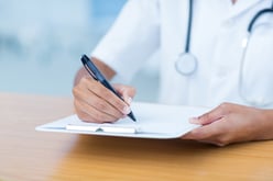 Doctor holding clipboard with file in hospital room-2