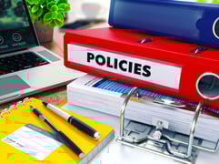 Policies - Red Ring Binder on Office Desktop with Office Supplies and Modern Laptop. Business Concept on Blurred Background. Toned Illustration.