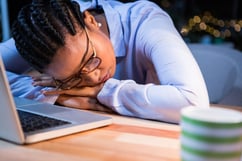 Tired businesswoman sleeping on the desk in the office