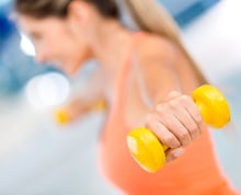 Woman at the gym lifting free weights